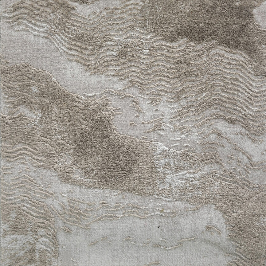 A close-up of the Elite Wave Carpet, featuring an elegant textured surface with flowing wave-like patterns in varying shades