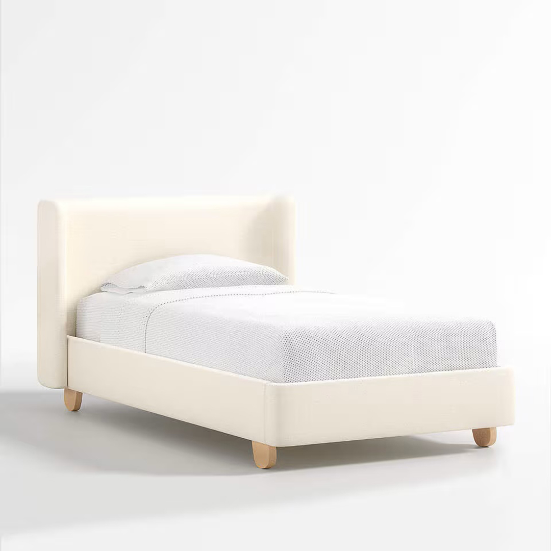 Cozy twin upholstered bed with natural cream fabric and red oak wood legs, inspired by West Coast elegance.